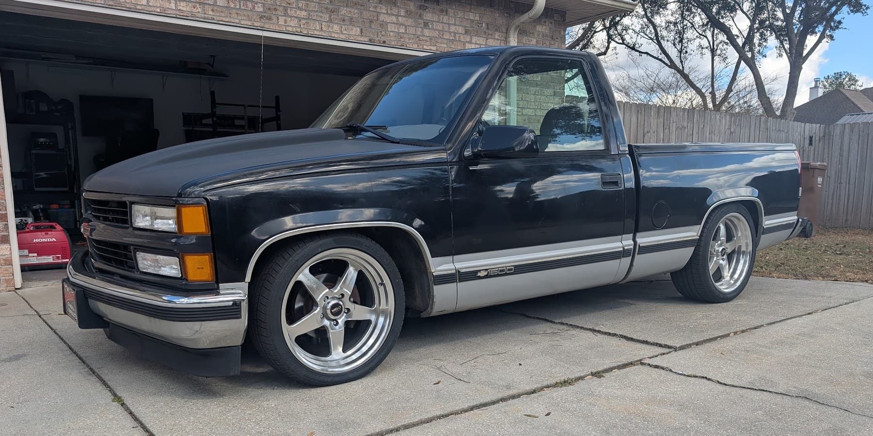 Lowered black 1988-98 Chevy C1500 pickup in a driveway